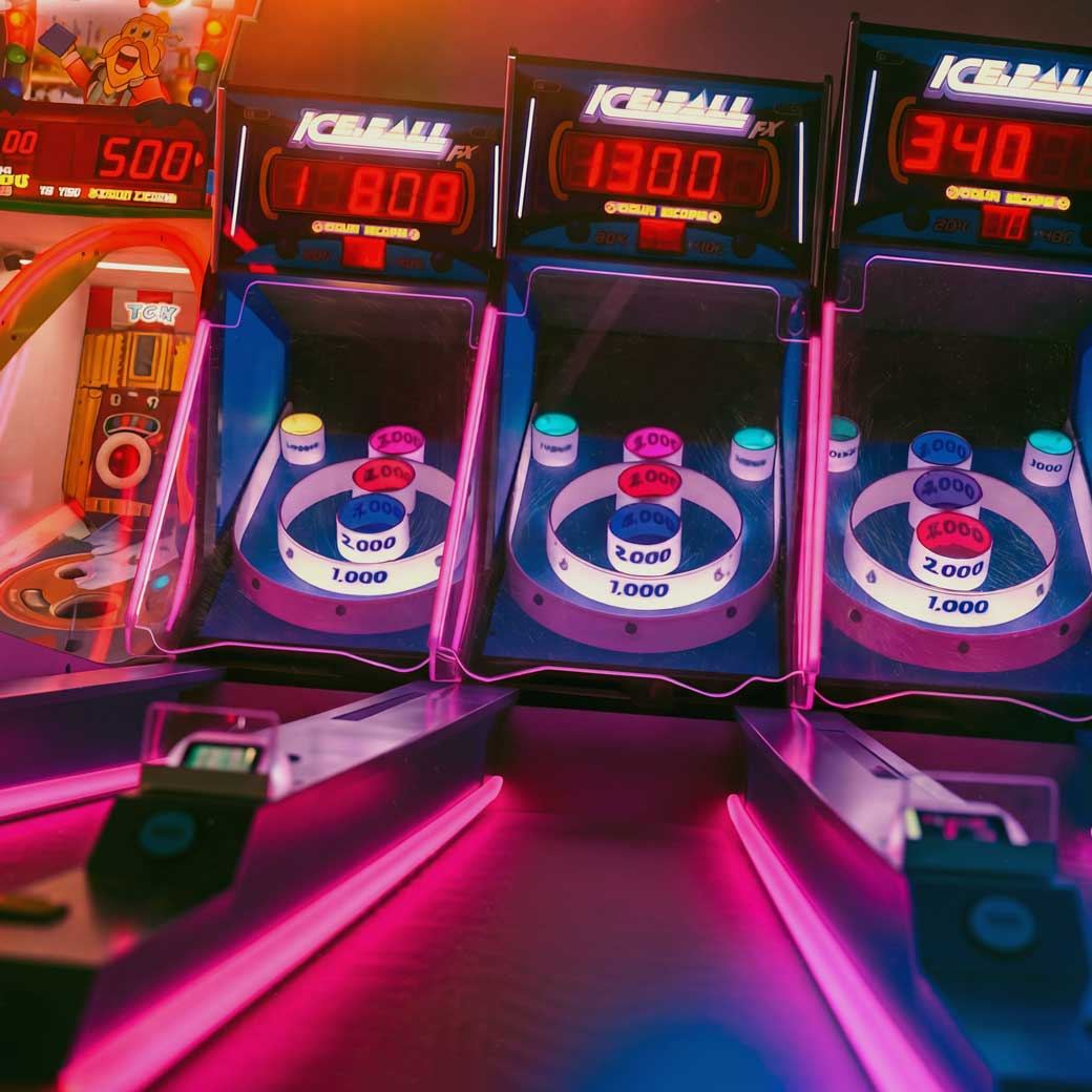 Ice Ball skee-ball arcade machines glowing pink in the game room
