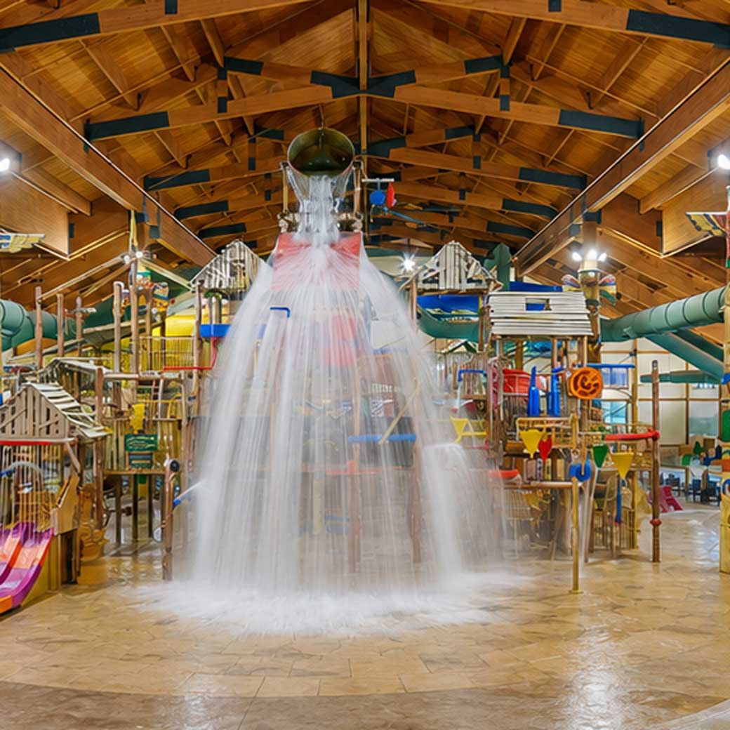 Indoor water park with a large wooden structure and slides, featuring a massive bucket pouring water onto the play area.