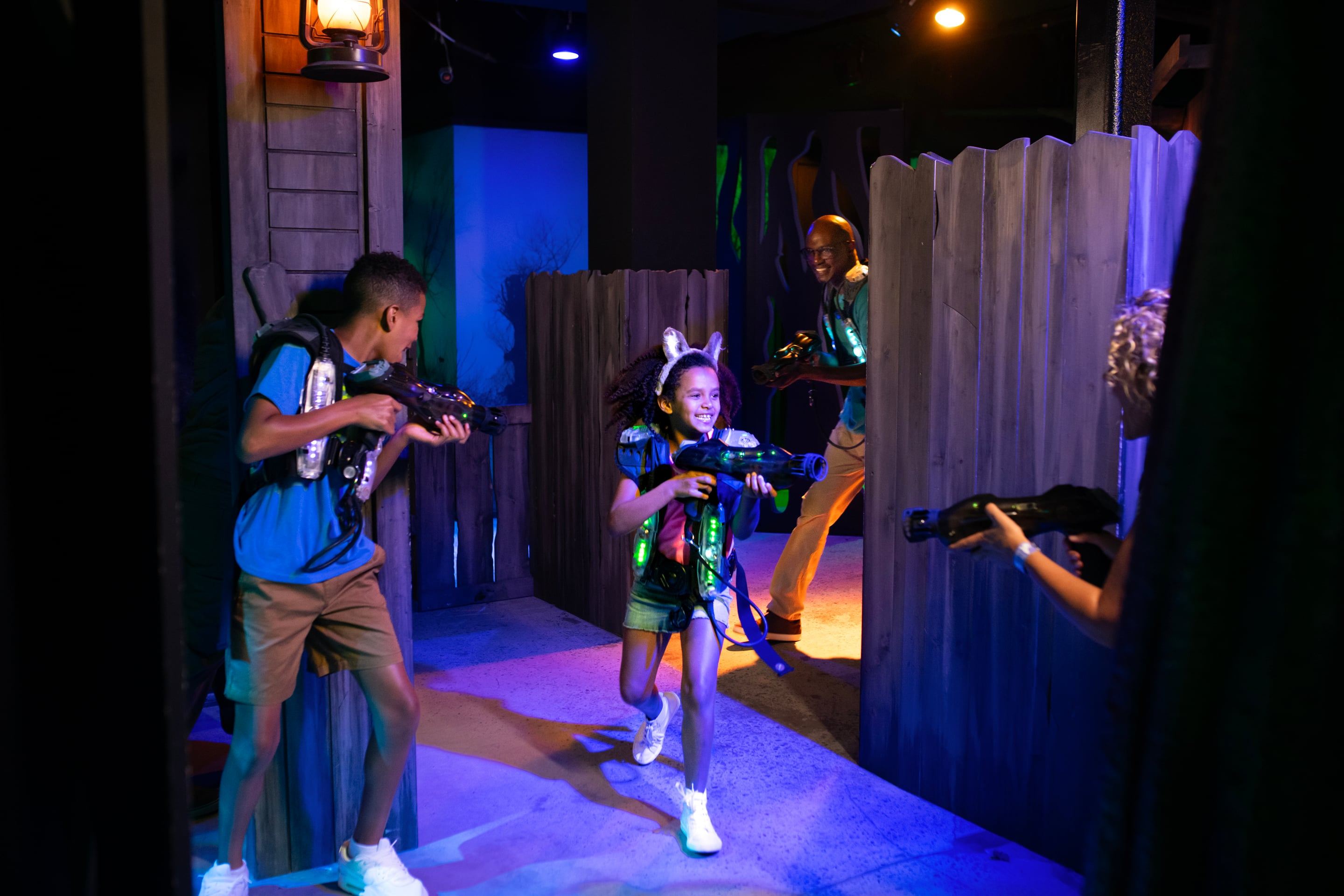 Family playing laser tag in a themed maze arena
