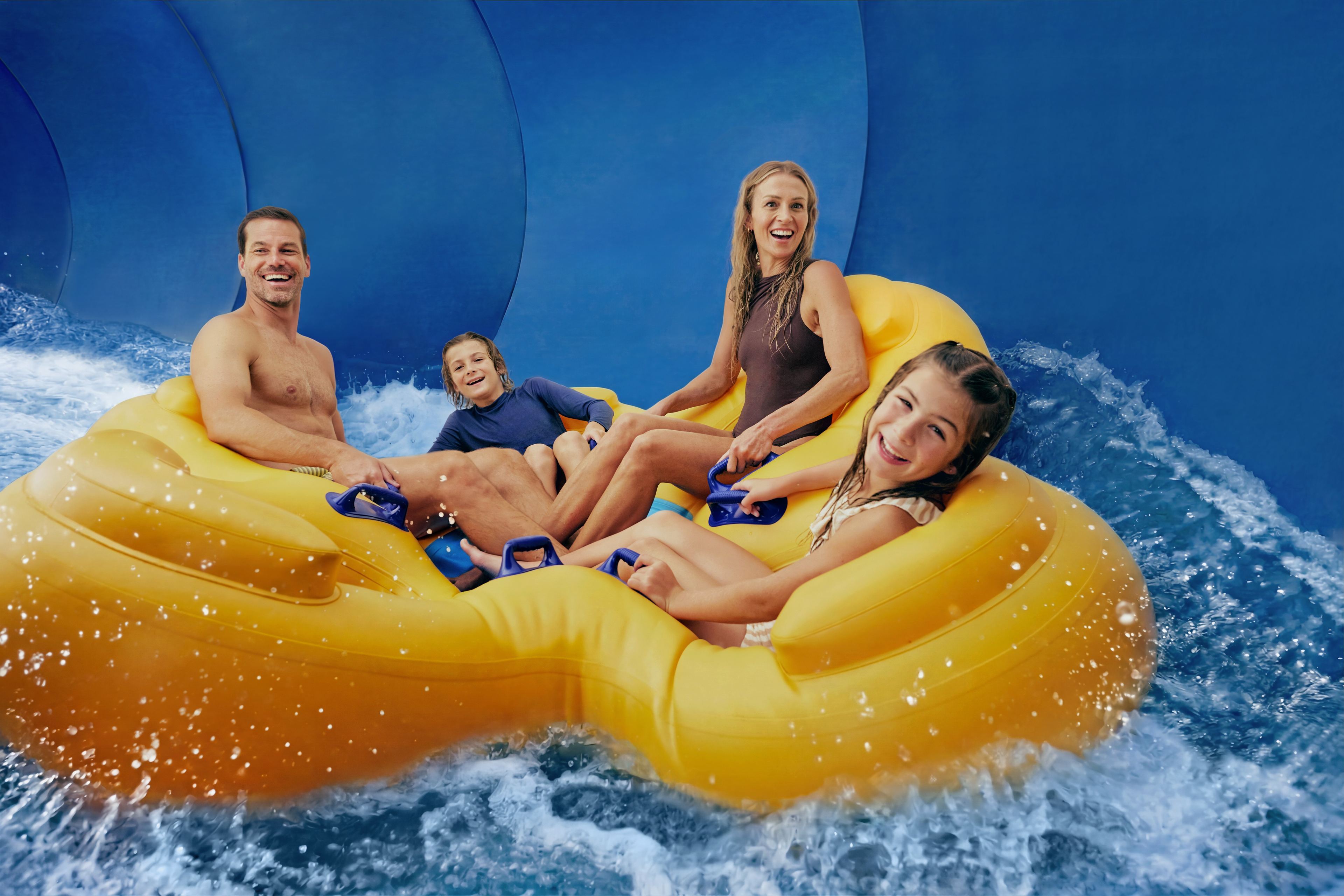 'A family of 4 enjoying a blue water slide'