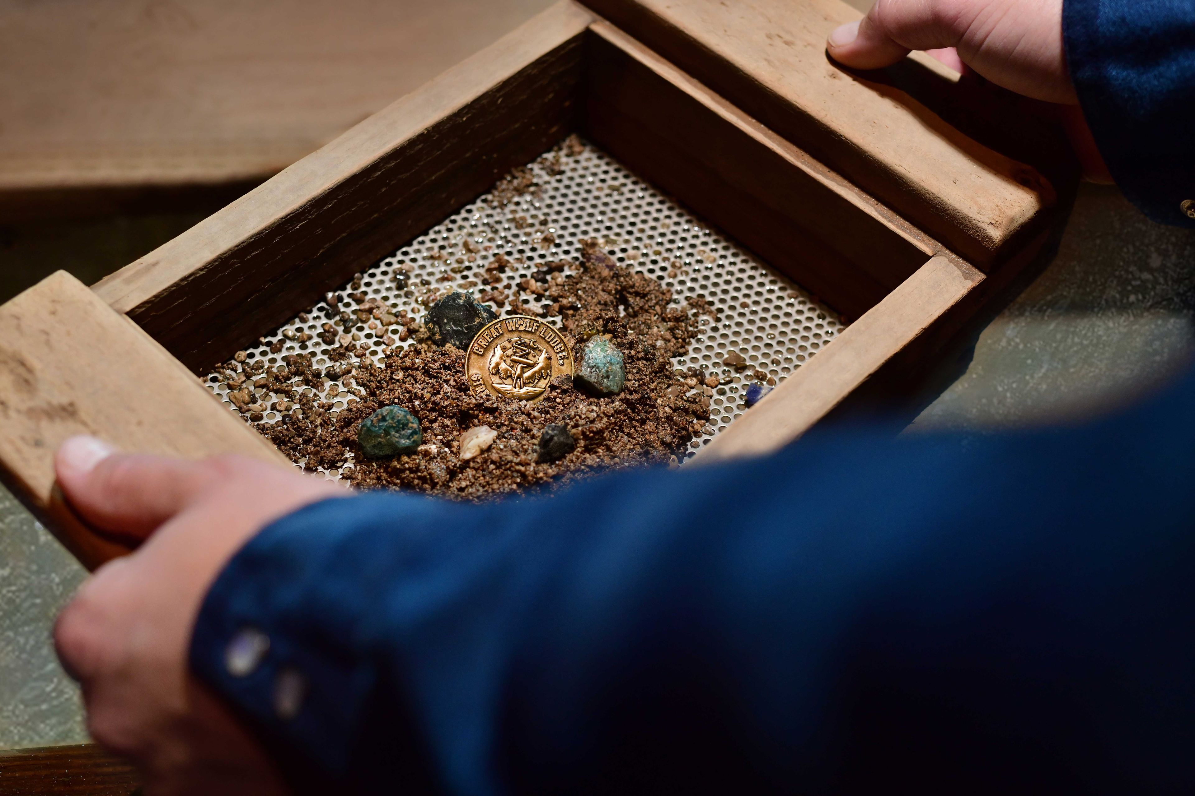 Child panning for gemstones at Oliver's Mining Company attraction